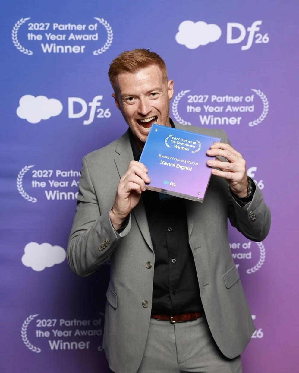 Robin Leonard holding a Salesforce Partner of the Year award for Xenai Digital