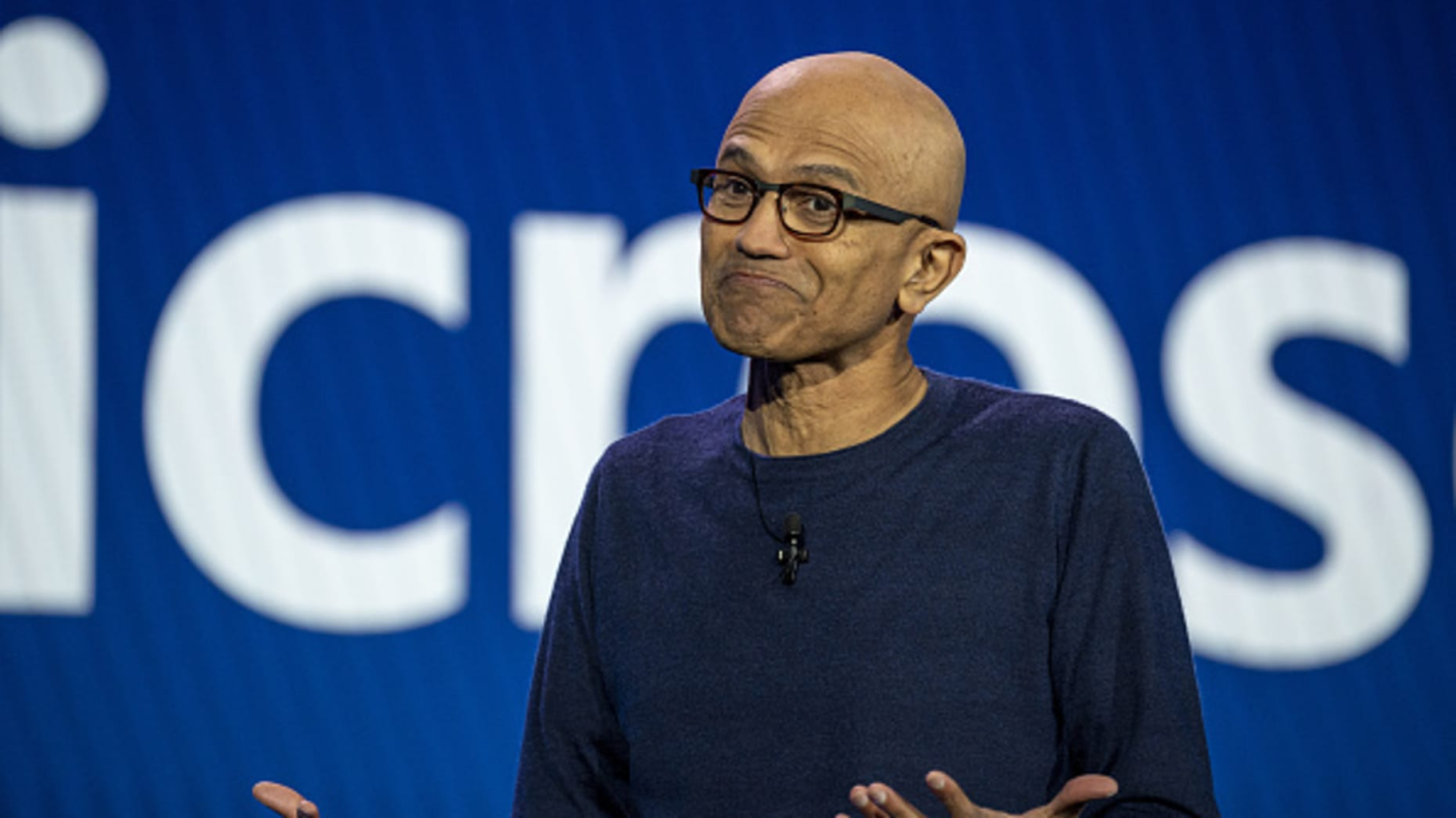 A technology leader on stage in front of a Microsoft backdrop